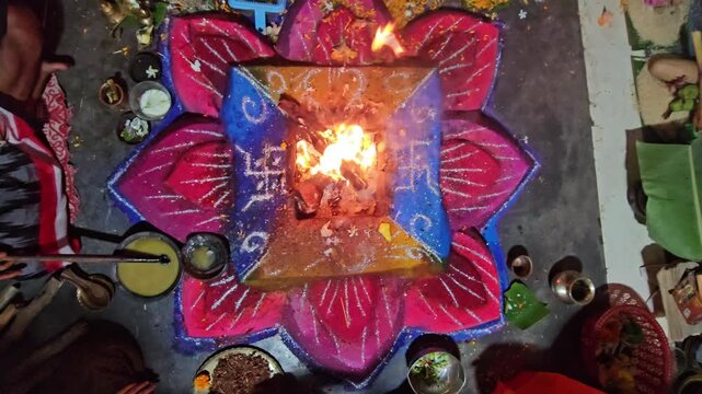 Hindu havan yajna ritual with sacred fire burning at the center of a decorated altar. The scene captures spiritual worship, offerings, and traditional religious ceremony. Ideal for themes of devotion