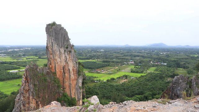Natural video background of a high-angle atmosphere on a mountain that overlooks the surrounding scenery(mountains, trees,sea)from a scenic vantage point,with a wooden chair for sitting and resting