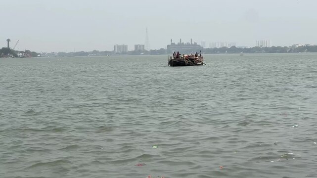 Artisanal fishing in West Bengal: A local fisherman rowing a small country boat on the Hooghly (Ganges) River, India