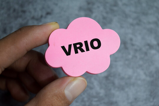 Concept of VRIO - Value Rarity Inimitability Organization write on sticky notes isolated on Wooden Table.