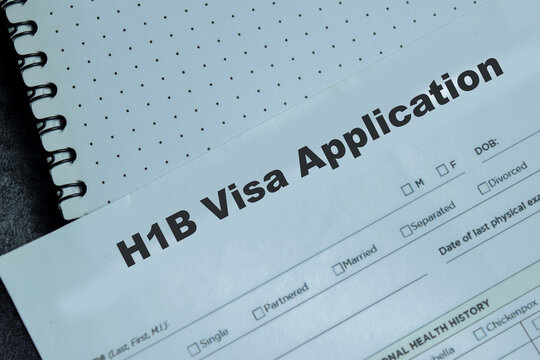 Concept of H1B Visa Application write on clipboard isolated on Wooden Table.