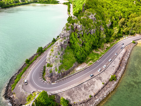 Aerial view of Maconde Viewpoint along the coastal road of Mauritius, featuring dramatic cliffs, winding road and turquoise waters of the Indian Ocean.