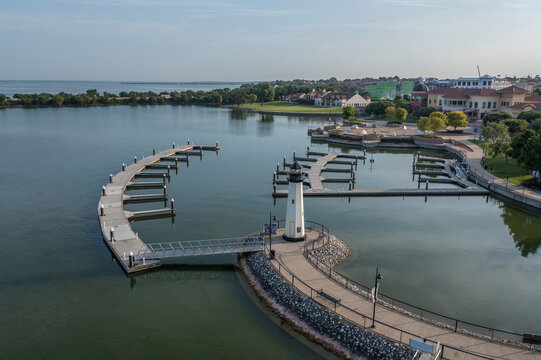 Lighthouse On Boat Dock Along Clear Blue Lake of Rockwall Harbor With Buildings in City of Rockwall, Texas in the Distance