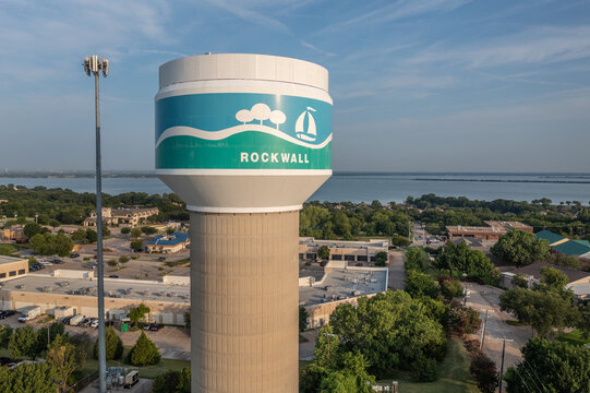 Aerial Drone View of Rockwall Water Tower and Surrounding Parking Lots and Buildings With Lake in the Distance in Rockwall, Texas
