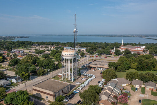 Aerial Drone View of Rockwall Water Tower and Surrounding Parking Lots and Buildings With Lake in the Distance in Rockwall, Texas