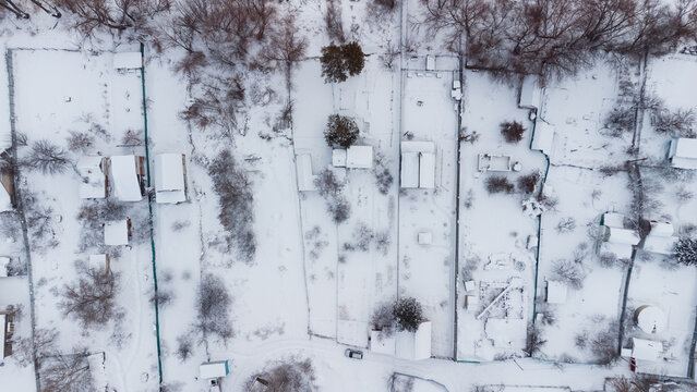 Aerial view of snow-covered houses near frozen river in Uralsk, Kazakhstan, during winter. c.