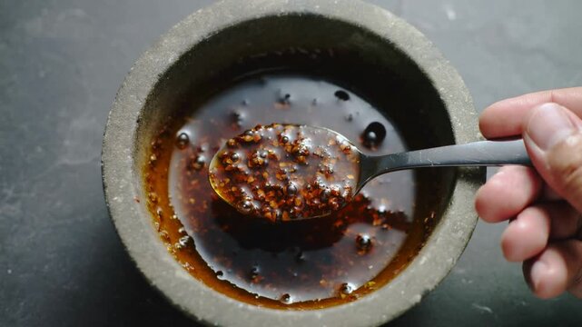 Crafting a vibrant spicy condiment in a timeless stone mortar, a culinary artistry unfolds with each stir