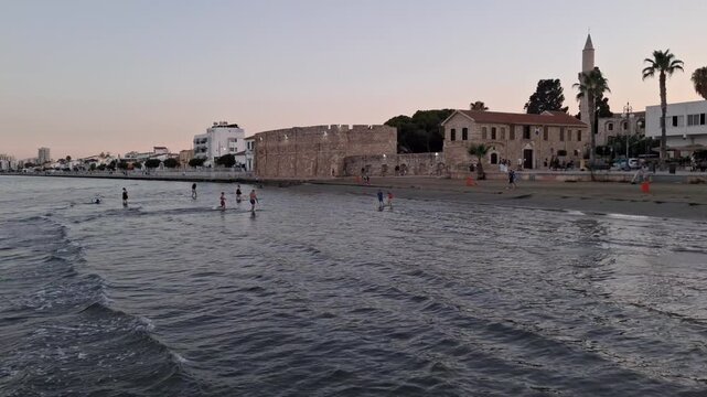 Larnaca Castle and the Minaret of the Djami Kebir Mosque alongside the mediterranean sea at sunset