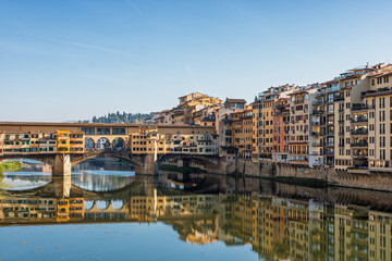 Fototapeta premium Famous historic Ponte Vecchio bridge and old buildings along the Arno river in Florence Italy
