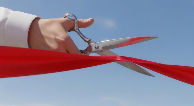 Hand cutting red ribbon with scissors