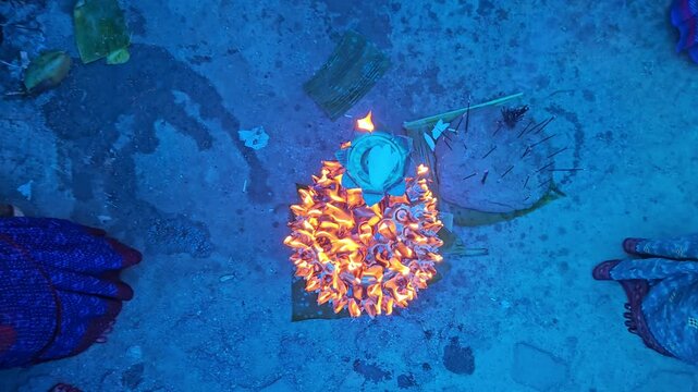 Top view of women lighting diyas together during an Indian festival, creating a beautiful circle of glowing flames. Dushara, Vijayadashami, Diwali celebration, spirituality, community bonding, and fes