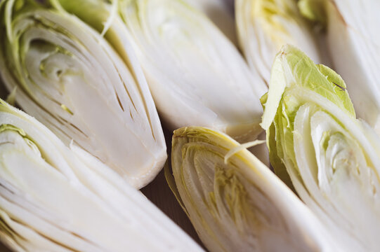 Fresh Belgian endive heads sliced in half, ready for salad preparation,Organic chicory vegetables, rich in fiber and vitamins, isolated close-up,Organic chicory vegetables, rich in fiber and vitamins,