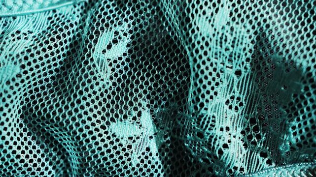 A close-up of emerald green lace fabric, showcasing its texture and fine detail. The delicate pattern and luxurious quality of the fabric. High quality 4k footage