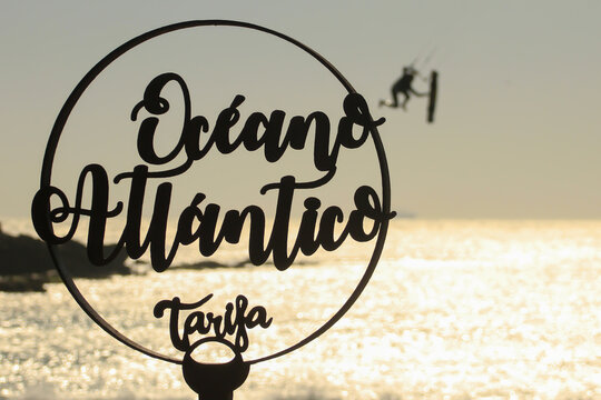 ecorative sign of Atlantic Ocean in Tarifa with a kite surfer silhouette in the background.