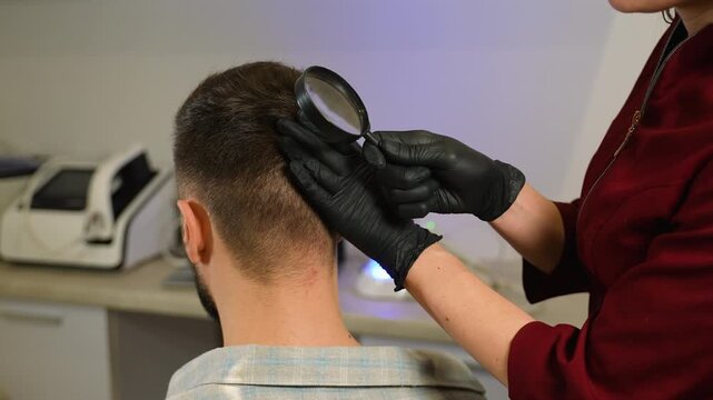 Trichologist examining man's hair and scalp for hair loss