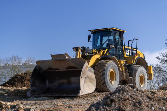 Nancy, France - March 1st 2025 : View on a yellow wheel loader CAT 972M for earthworks on a construction site with the blue sky.