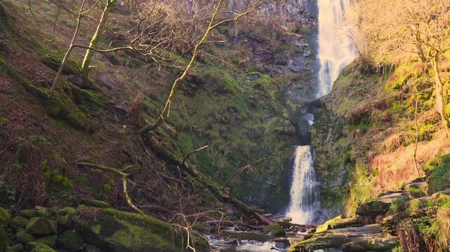 View of the lower section of the Pistyll Rhaeadr waterfall in Wales, UK during springtime with harsh sunlight