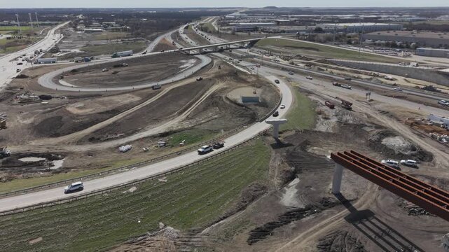Denton, Texas USA &ndash; February 18, 2026: Aerial view of a highway interchange under construction with elevated ramps, bridge supports, and vehicle traffic on surrounding roadways.