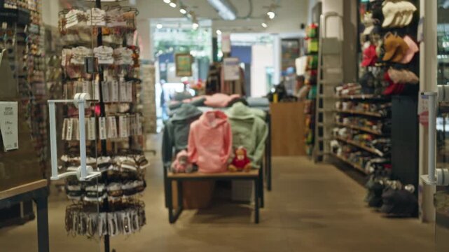 Blurry view of a clothing shop interior with various accessories and apparel on display, showcasing a casual and inviting shopping environment indoors.