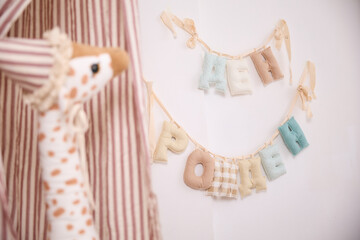Boho children's room details with soft Russian alphabet garland and giraffe © Анастасия Правдюк