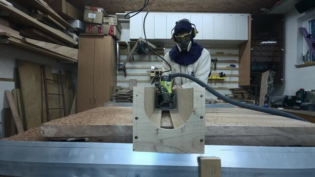 Aggressive Real Time Router Action by Faceless Maker in Hazard PPE Surfacing Timber Slab Low Angle Handheld Authentic Garage