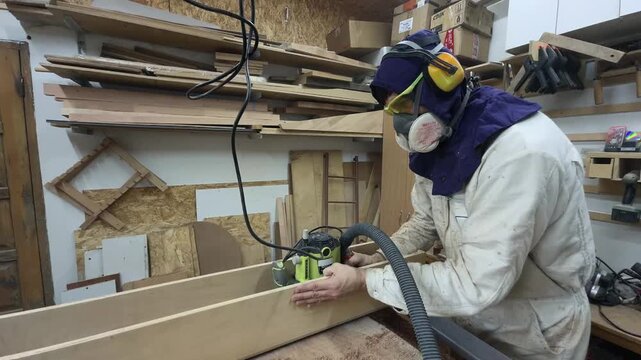 Dedicated Entrepreneur in Full PPE Leveling Slab with Router in Cluttered Garage Workshop Vertical Tracking Slow Motion Blue Collar Startup Grit