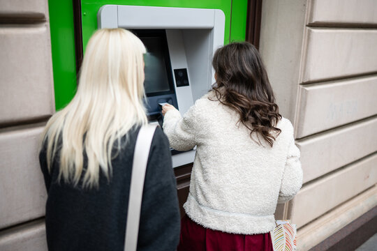 Woman withdrawing cash from atm using credit card