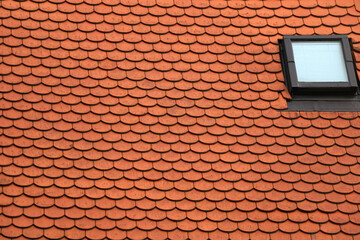 Fototapeta premium Slate roof with traditional red tiles and windows. 