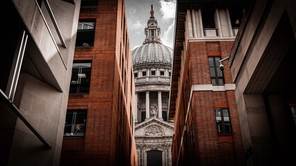 St Paul's Cathedral dome framed between red brick buildings in narrow London alley © Aaron