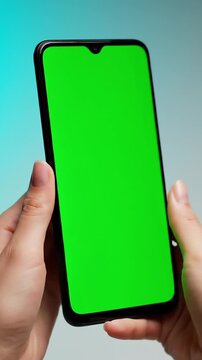 Iphone Mockup, Hand holding smartphone with green screen and notch, captured in gradient background, perfect for app presentation product advertisement showcase
