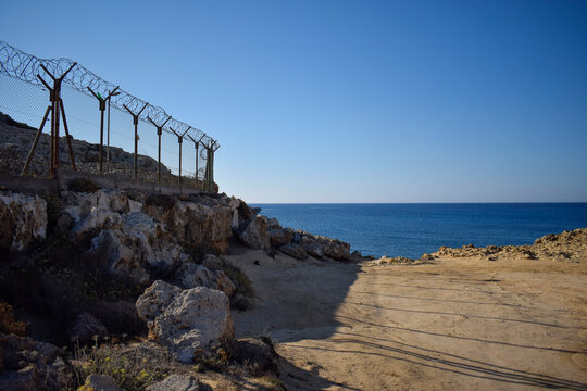 Barbed Wire Fence on Rocky Coastline near Cape Greco Geko Bench, Cyprus
