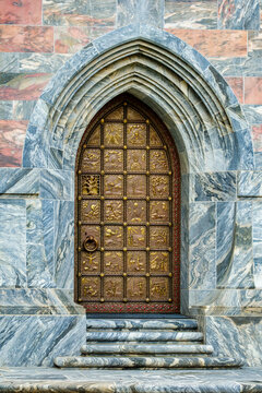 Explore Historic Architecture: Ornate Metal Door with Intricate Carvings and Stone Archway at Bok Tower Gardens in Lake Wales, Florida, USA