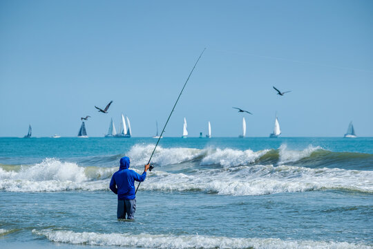 Experience Coastal Serenity: Fishing by the Ocean with Sailboats and Seagulls in New Smyrna Beach Florida, USA