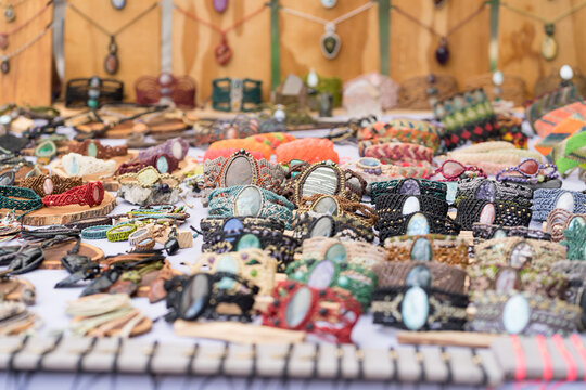 Artisan crafting unique macrame bracelets with natural stones at an outdoor market stall