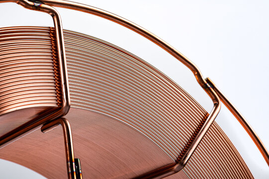 Copper coated MIG welding wire on wire spool. Upper part of a copper wire coil on a metal frame, clean white background.