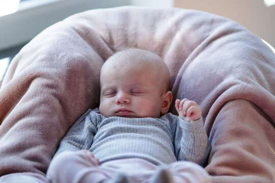 Baby sleeps in cozy chair during afternoon light