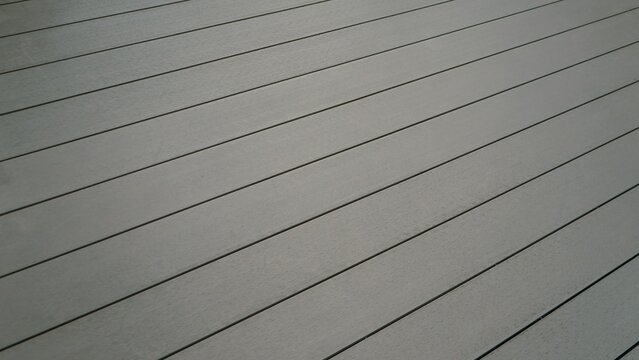 Grey composite wood decking planks in diagonal perspective view.