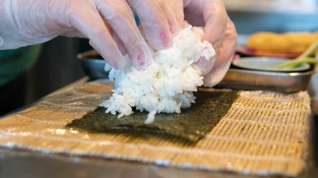 chef preparing sea urchin rolls Chef hands preparing sushi roll, squeeze out cream cheese