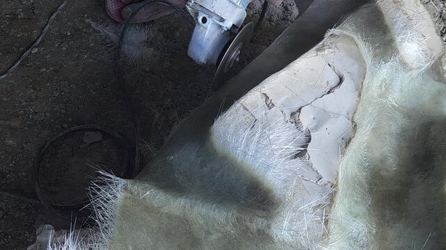 Close-up of a skilled artist using an angle grinder to cut and shape a fibre sculpture, captured in slow motion. The scene highlights precision craftsmanship, manual work, and industrial tools, India