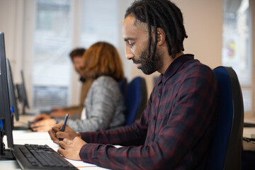 Fototapeta premium employé de bureau, homme d'affaires ou salarié qui est à son poste de travail. avec ses collègues en arrière plan. Bonheur au travail.