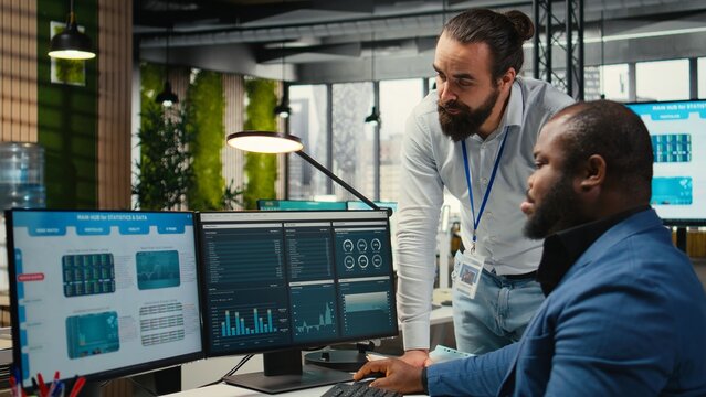 Diverse corporate team focuses on data management on computer, planning strategies for company growth and aligning objectives with performance metrics for measurable productivity.