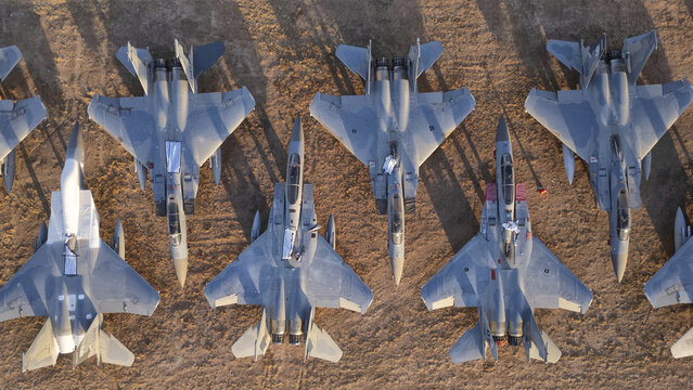 Tucson, United States - 30 January 2025: Aerial view of the formidable array of fighter jets parked in neat rows, their metallic surfaces glinting under the desert sun.