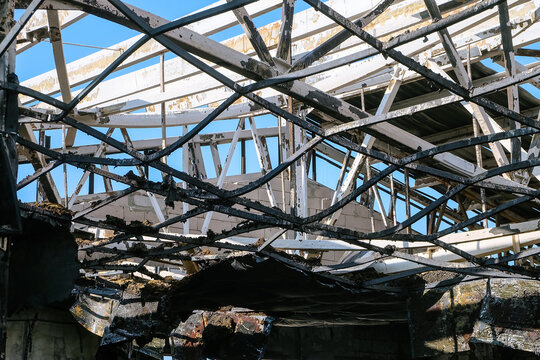 Thermal deformation. Damaged by fire metal roof structures in steel frame.
