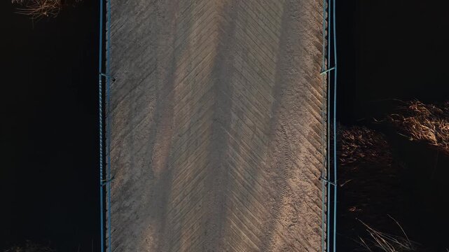 Aerial Rise Over Wooden Herringbone Bridge at Golden Hour