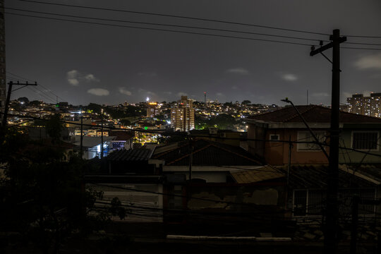A street in the southern part of S&atilde;o Paulo is plunged into darkness during a blackout caused by heavy rains. The image exposes the vulnerability of urban infrastructure, where overhead wiring, visible