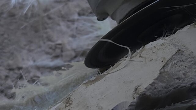 Close-up of a skilled artist using an angle grinder to cut and shape a fibre sculpture, captured in slow motion. The scene highlights precision craftsmanship, manual work, and industrial tools, India