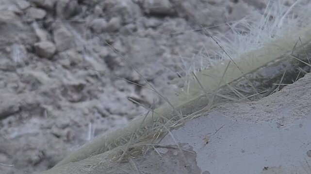 Close-up of a skilled artist using an angle grinder to cut and shape a fibre sculpture, captured in slow motion. The scene highlights precision craftsmanship, manual work, and industrial tools, India