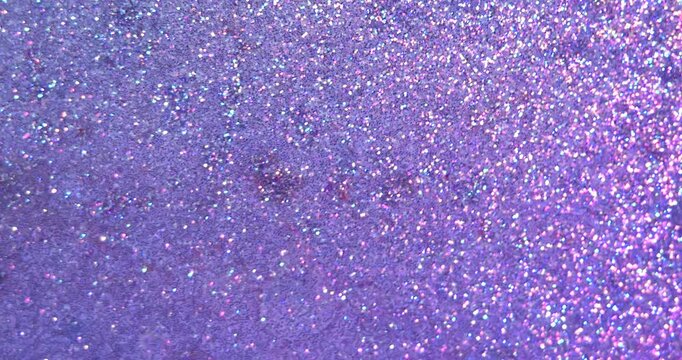 Abstract background with shiny glitter on the surface of a liquid, illuminated by pink and blue light, creating dramatic fluid texture for creative design and modern art concepts. Slow motion.