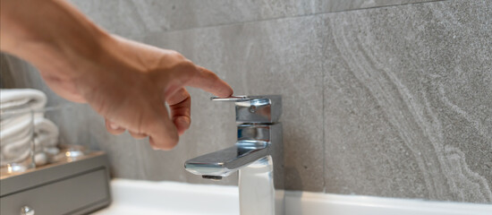 Naklejka premium Save water. Volunteer keeps turning off the running water in the bathroom to protect environment. Greening planet, reduce global warming, Save world, life, future, risk energy, crisis , water day.