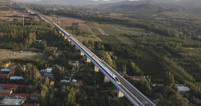 High-speed railway train traveling on the Beijing&ndash;Shanghai High-Speed Railway (Jinghu HSR) in China. Modern bullet train running on elevated tracks through the countryside, showcasing advanced transpo